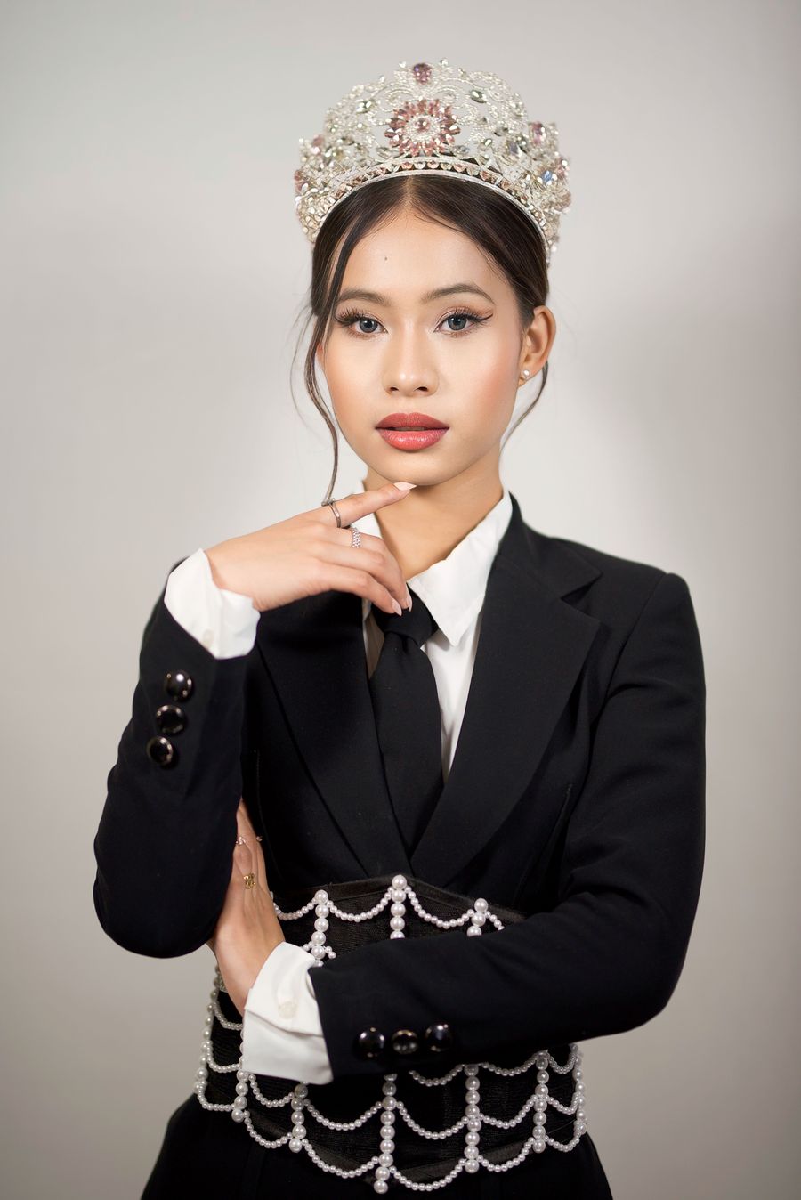 Rupda in a black suit wearing a crown