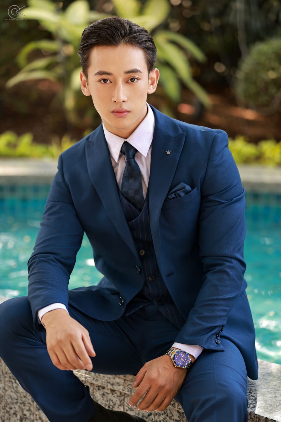 Songashim Rungsung in a navy suit by a pool
